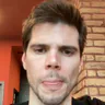 Dávid Kiss in a dark top, speaking to camera in a restaurant with exposed brick