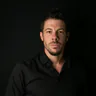 Forrest Webber in dramatic side lighting against a black studio backdrop