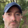 Matthew Marley in a cap and grey top, photographed on a wooded trail